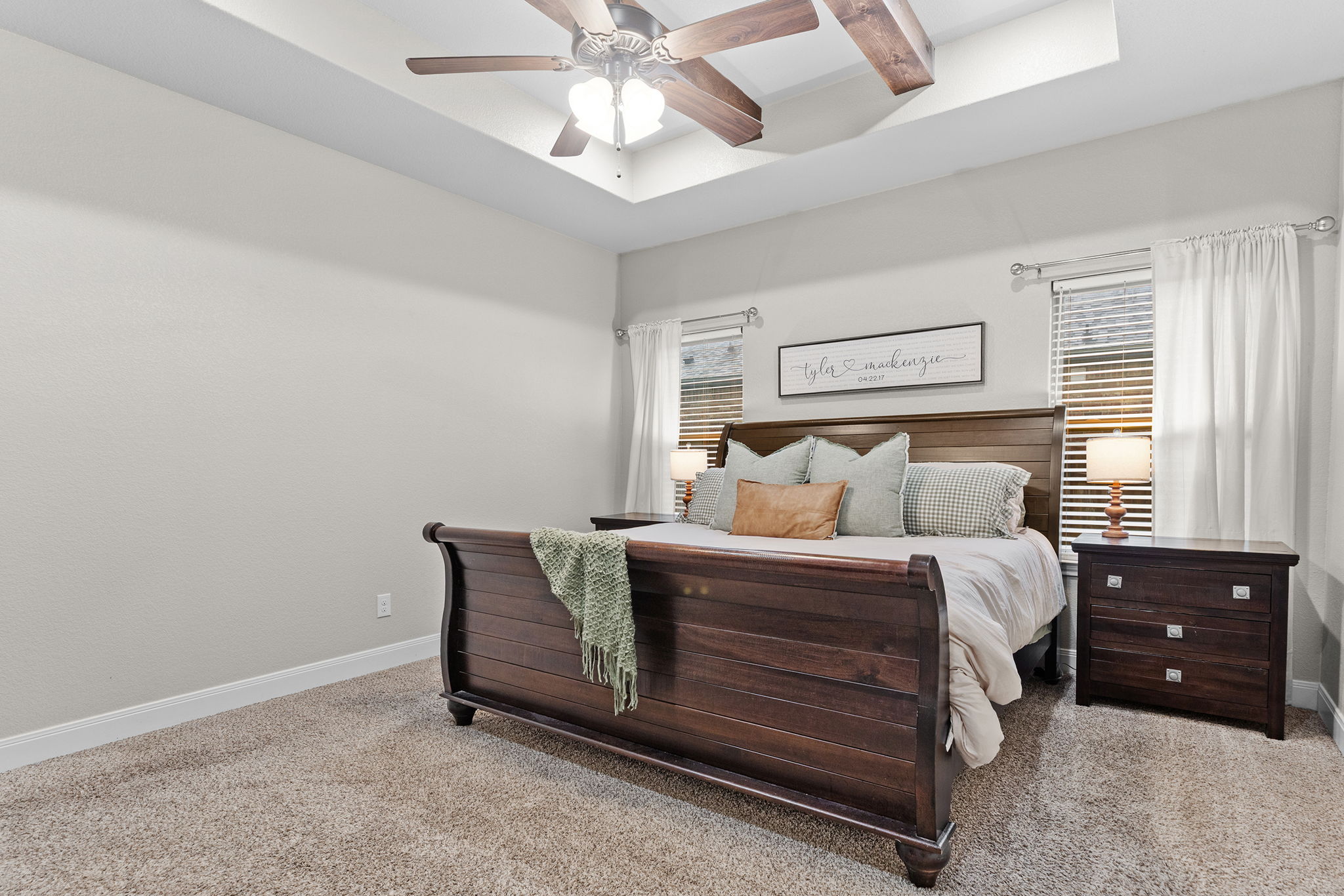 161 Greg Lane Jarrell, TX 76537 - Photo 27 of 35 Recessed tray ceiling with a wood-finish ceiling fan, neutral carpeting, and multiple windows with blinds and curtains