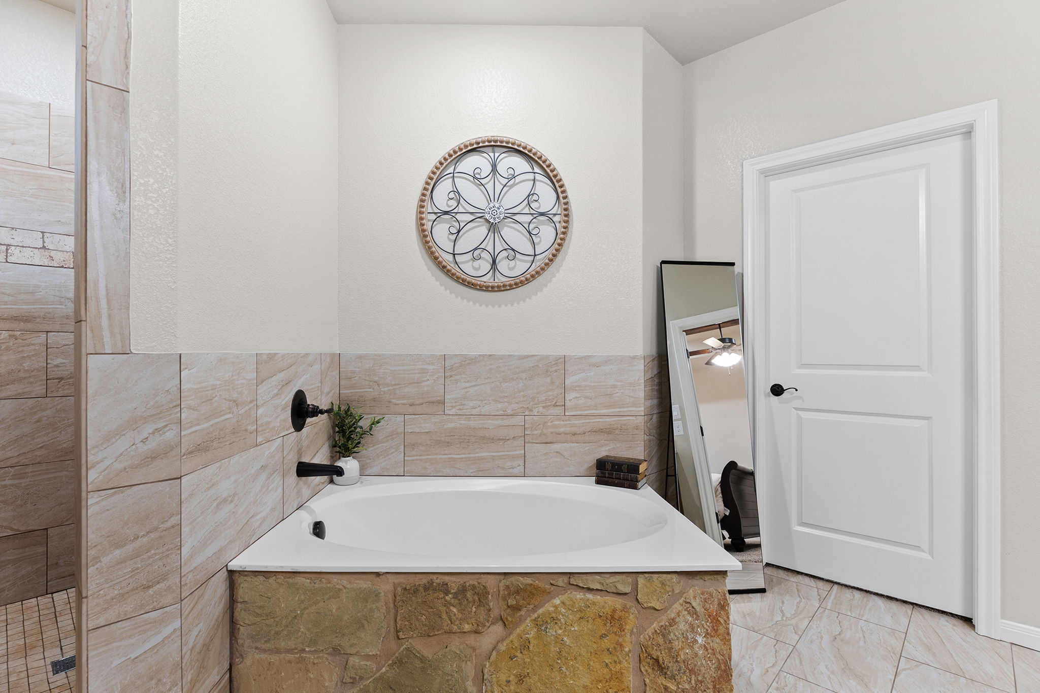 161 Greg Lane Jarrell, TX 76537 - Photo 30 of 35 Built-in soaking tub with a natural stone surround and matte black fixtures