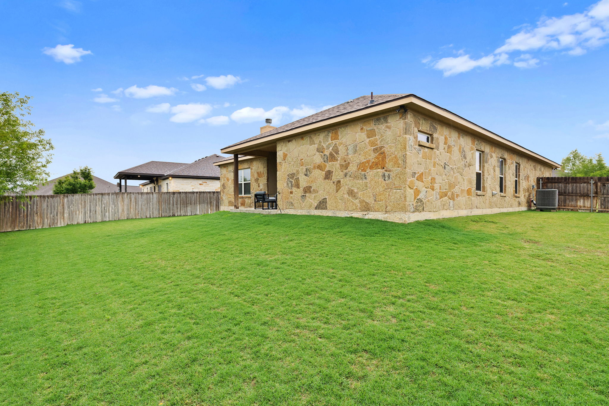 161 Greg Lane Jarrell, TX 76537 - Photo 33 of 35 Expansive green lawn bordering a natural stone exterior