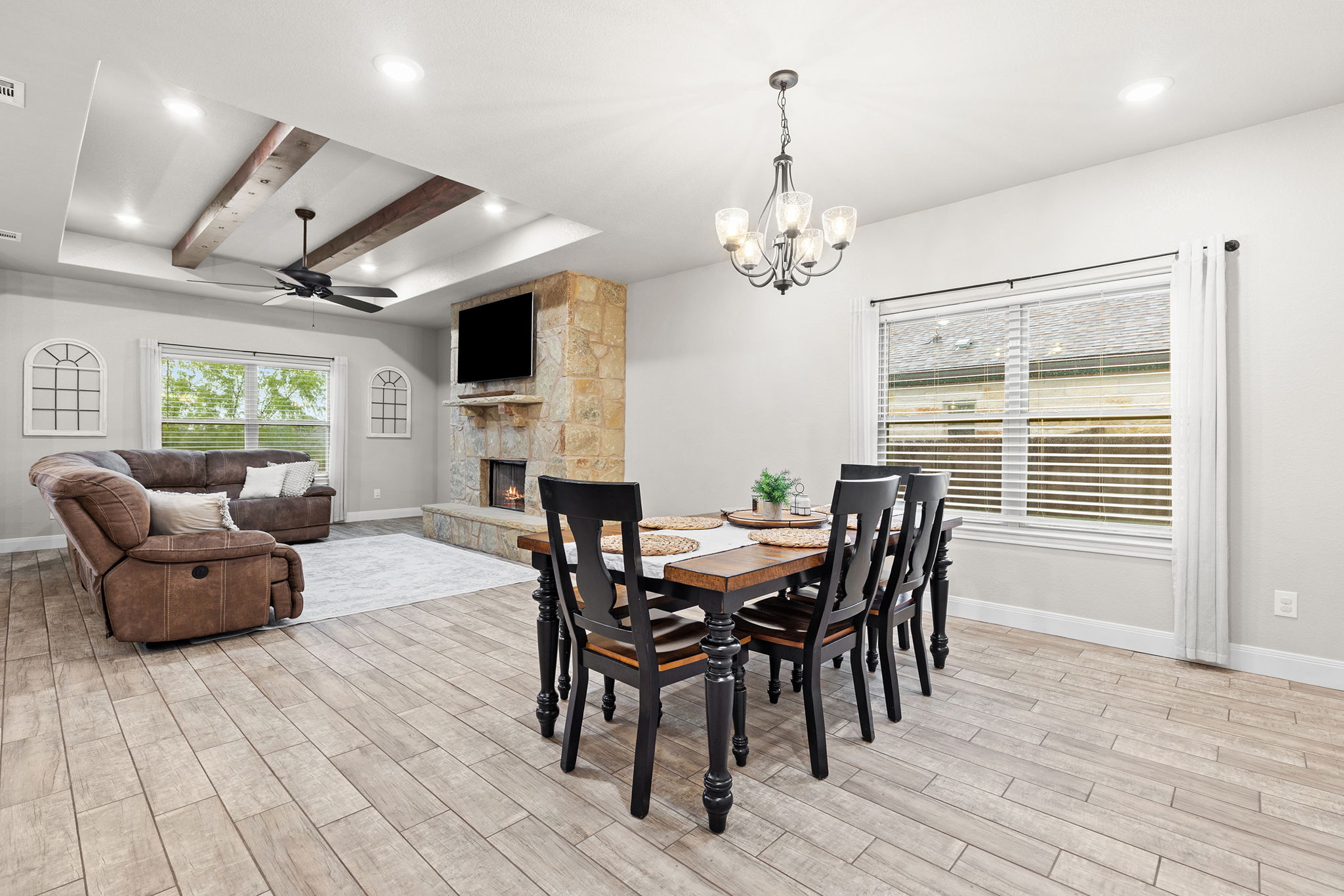 161 Greg Lane Jarrell, TX 76537 - Photo 6 of 35 Open-concept room featuring wood-finish flooring, a tray ceiling with exposed beams, recessed lighting, and a stone-clad fireplace