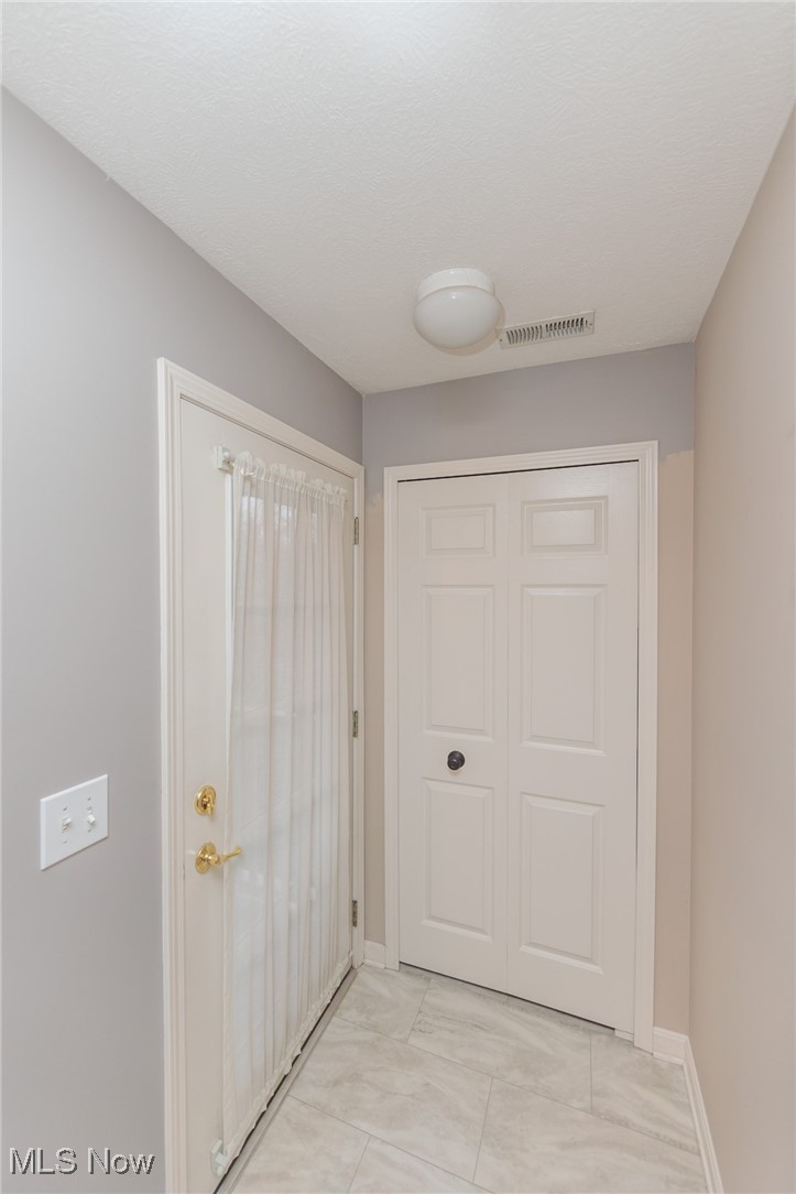 28360 Center Ridge Road, Unit 2210 Westlake, OH 44145 - Photo 9 of 45 Doorway featuring a textured ceiling and light tile patterned floors