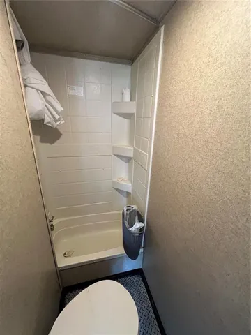 a bathroom with a toilet and a shower