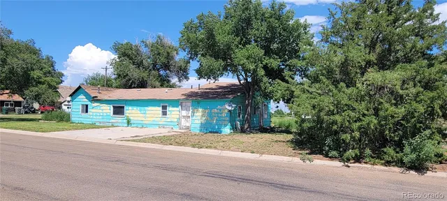 a front view of a house with a yard and trees