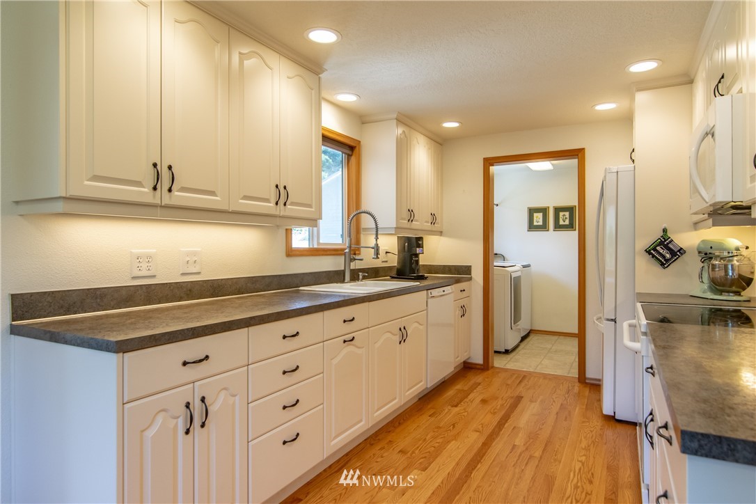 2245 Happy Valley Road Sequim, WA 98382 - Photo 8 of 25 a kitchen with cabinets and wooden floor