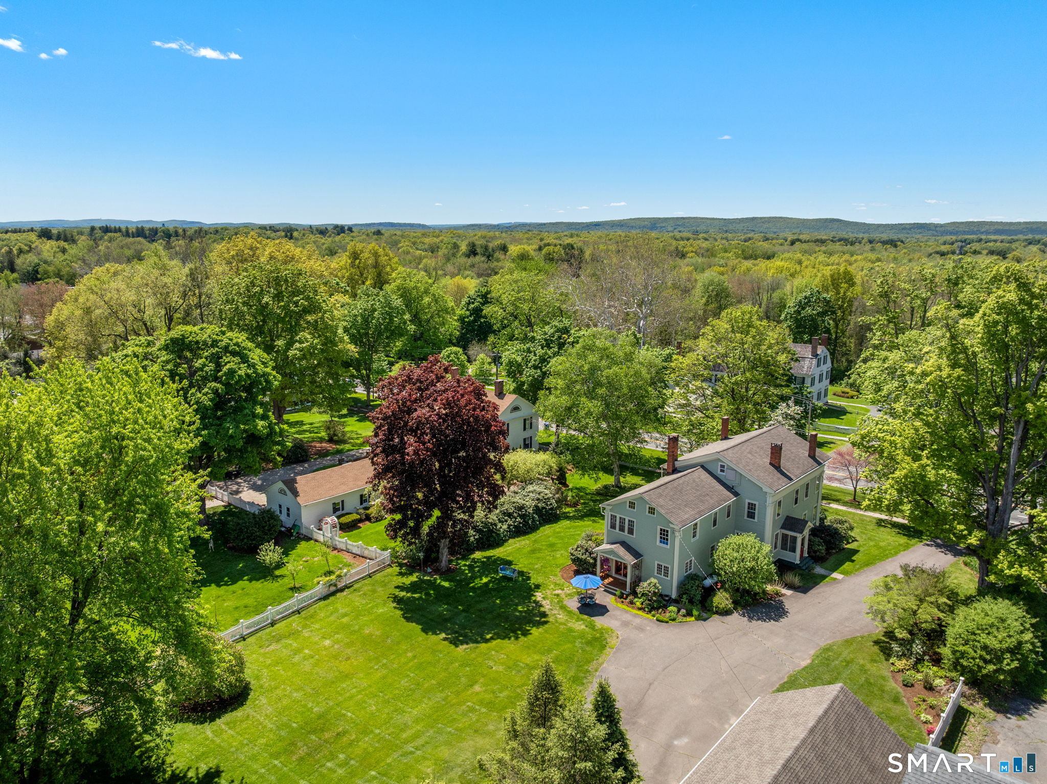 52 South Main Street Suffield, CT 06078 - Photo 37 of 40 an aerial view of green landscape with trees houses and mountain view