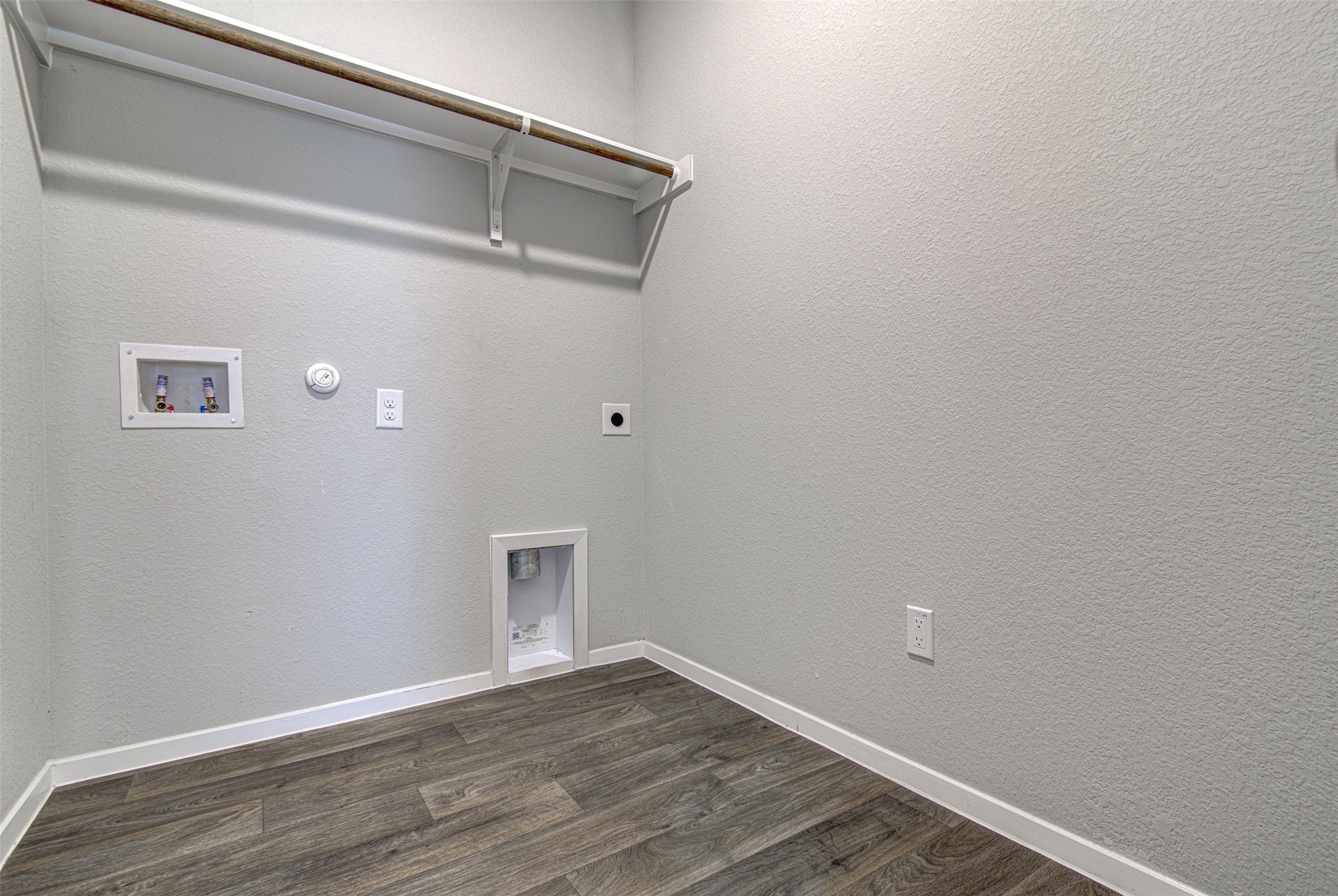156 Tillage Road Elgin, TX 78621 - Photo 19 of 25 A dedicated utility space, providing essential connections for laundry appliances and a convenient overhead shelf.