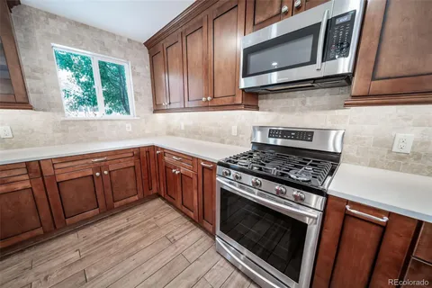 a kitchen with wooden cabinets and a stove top oven