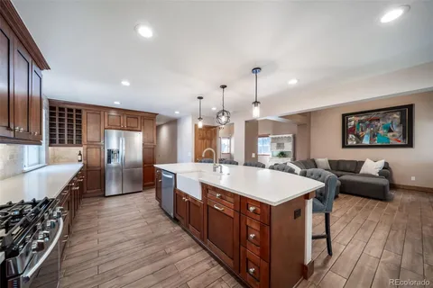 a large kitchen with stainless steel appliances a large counter top and wooden floors