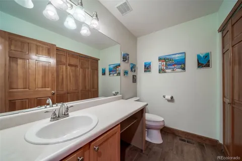 a bathroom with a sink vanity granite and toilet
