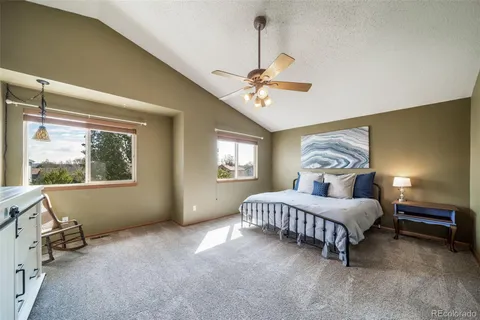 a bedroom with a bed chandelier and windows