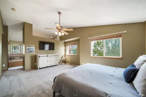 a bedroom with a large bed and a flat tv screen on dresser