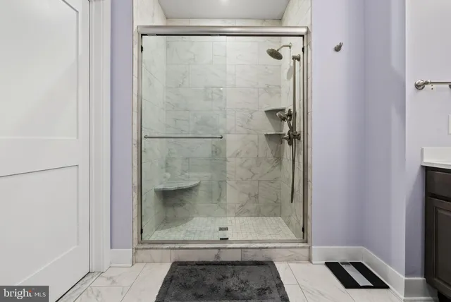 a bathroom with a sink a toilet a mirror and shower