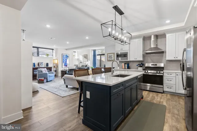 a kitchen with stainless steel appliances granite countertop a stove and white cabinets