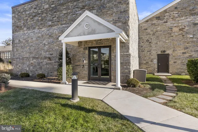 a kitchen with stainless steel appliances granite countertop a dining table chairs refrigerator and microwave