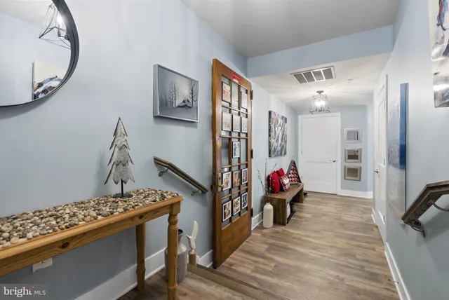 a kitchen with stainless steel appliances granite countertop a dining table chairs refrigerator and microwave