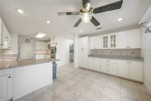 a large kitchen with cabinets stainless steel appliances a sink and a counter top space