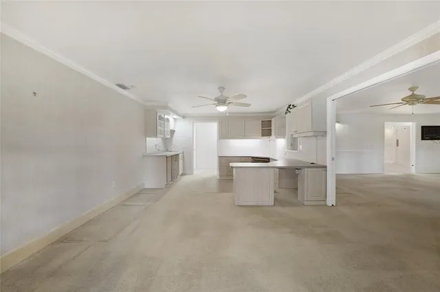 a large white kitchen with cabinets a sink and appliances