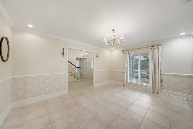 en empty room with chandelier and glass door