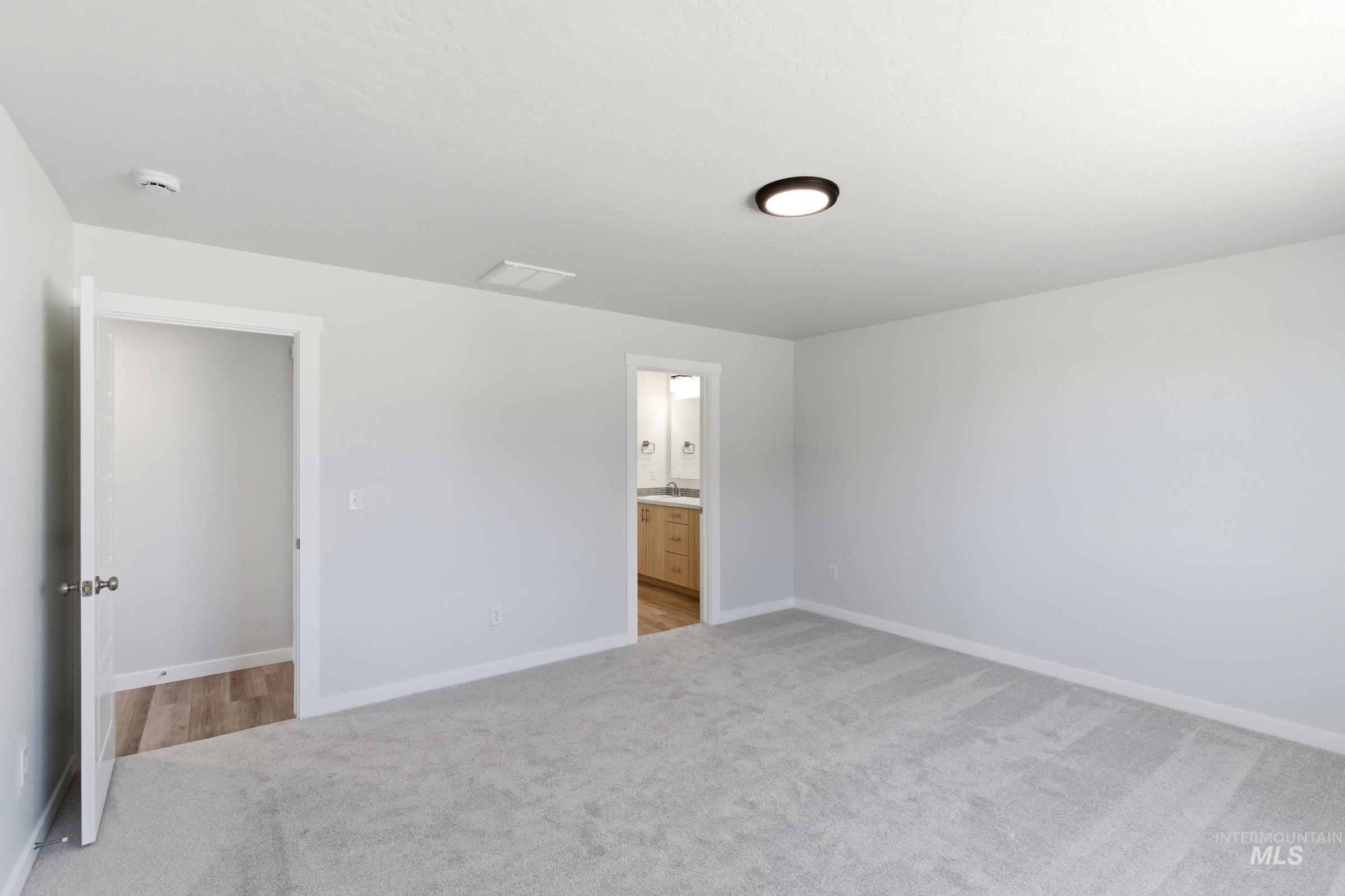 8317 South Tyrion Way Kuna, ID 83634 - Photo 18 of 22 Spacious interior room featuring light gray carpeting and white painted walls
