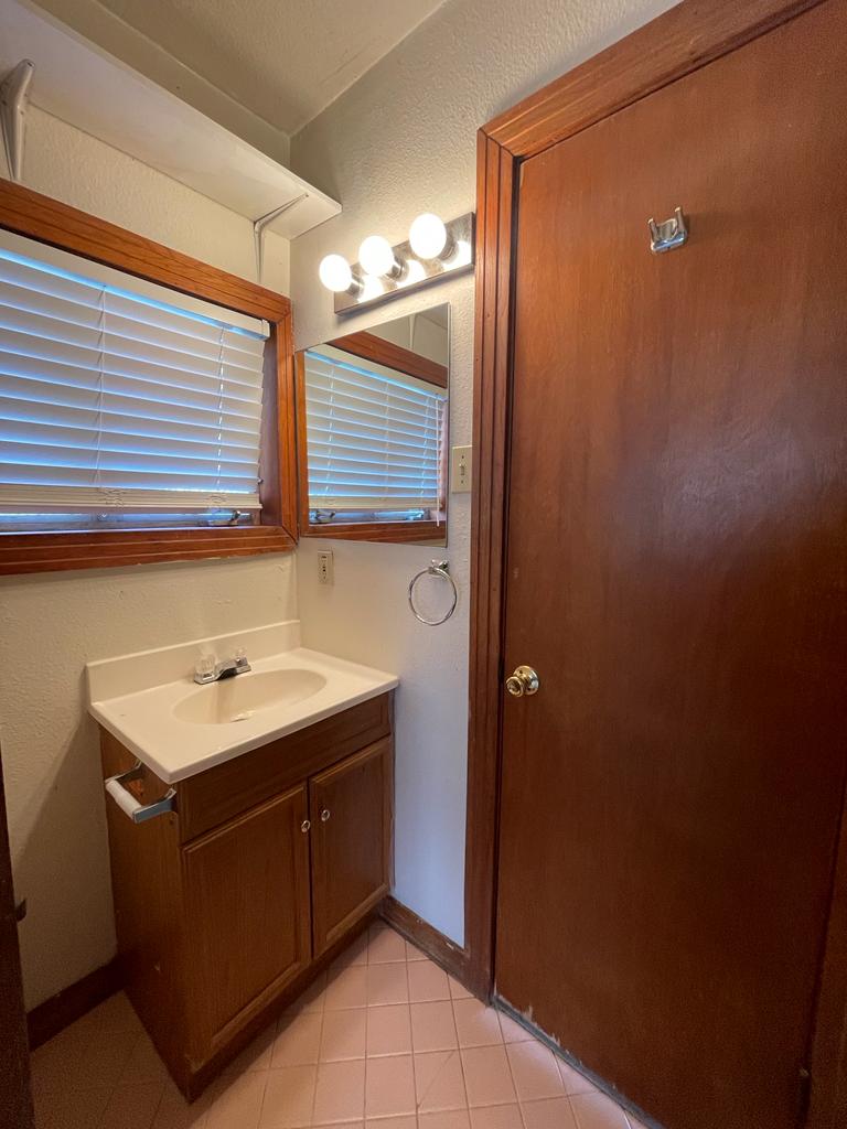 108 Austin Street, Unit B Kyle, TX 78640 - Photo 10 of 14 A well-lit bathroom features a functional vanity and window, ready for everyday use.