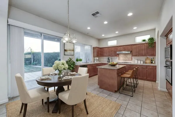 a large kitchen with stainless steel appliances kitchen island granite countertop a refrigerator and a sink