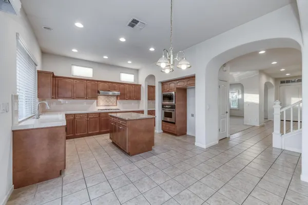 a large kitchen with stainless steel appliances granite countertop a large counter top and oven