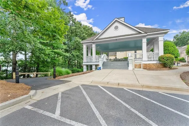 a front view of a house with a garden and trees