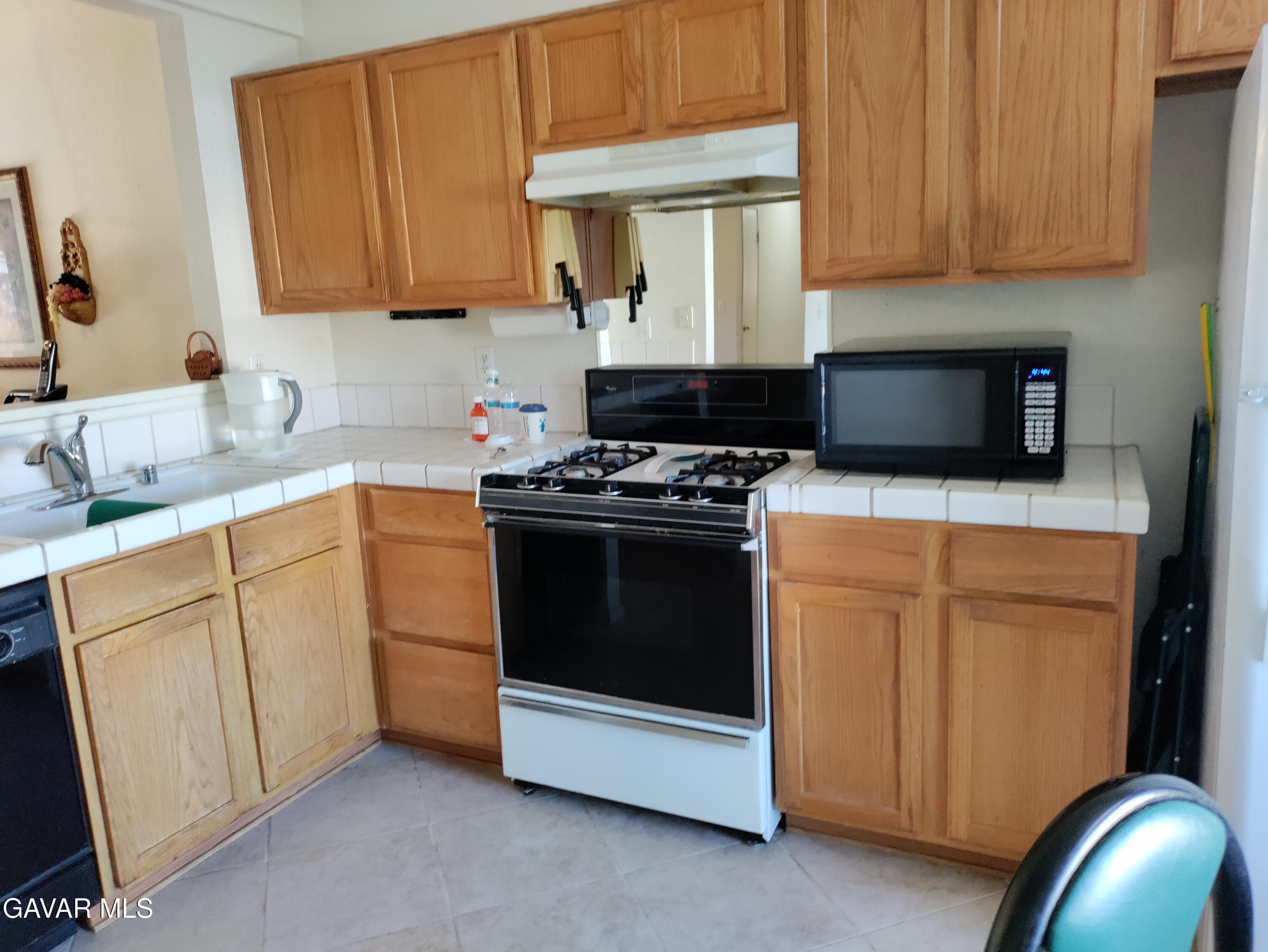 37759 67th Street East Palmdale, CA 93552 - Photo 3 of 27 a kitchen with granite countertop cabinets stainless steel appliances and a sink