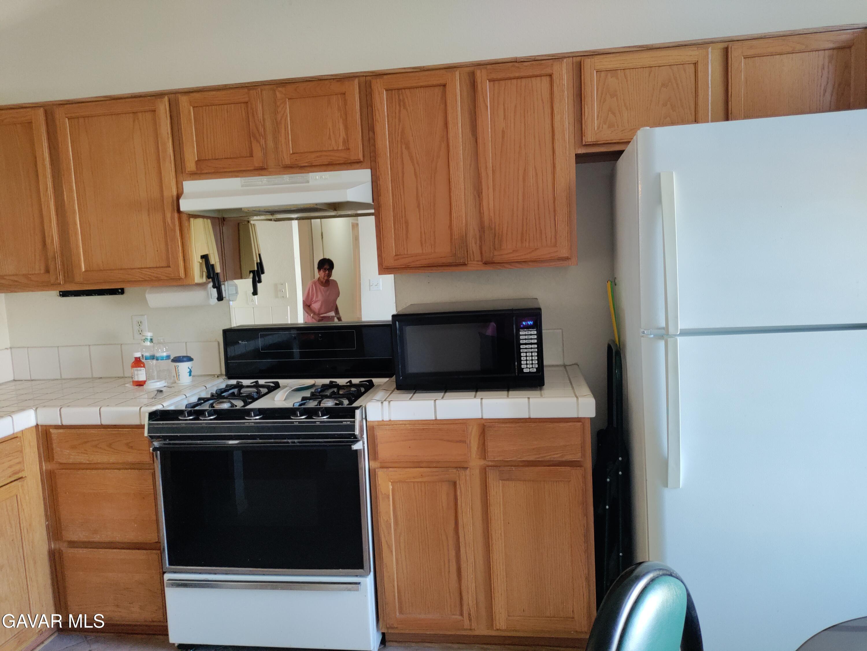 37759 67th Street East Palmdale, CA 93552 - Photo 4 of 27 a kitchen with stainless steel appliances granite countertop a refrigerator stove a sink and dishwasher