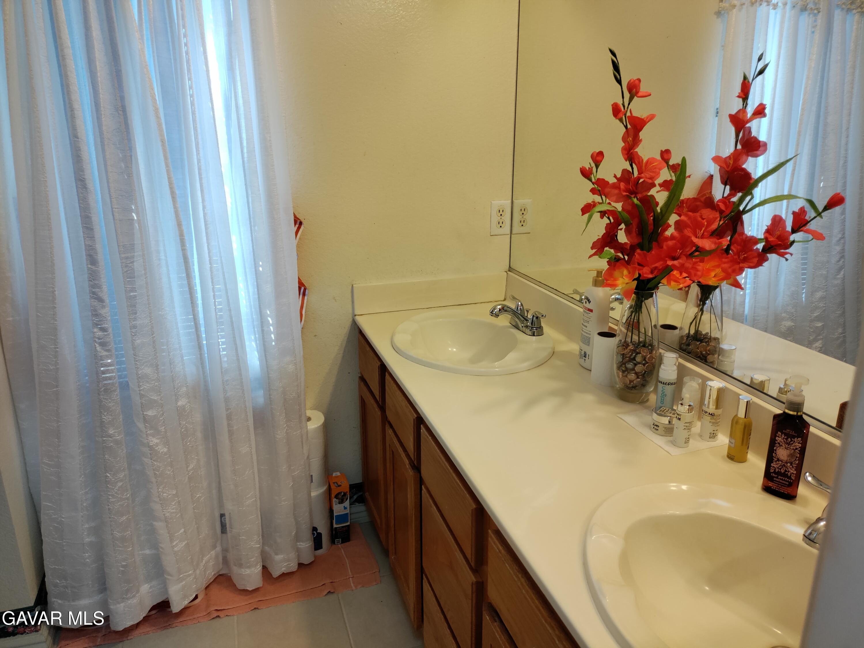 37759 67th Street East Palmdale, CA 93552 - Photo 10 of 27 a bathroom with a sink vanity and a mirror