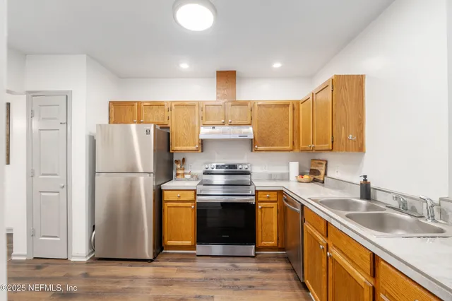a kitchen with stainless steel appliances granite countertop a sink a stove and cabinets