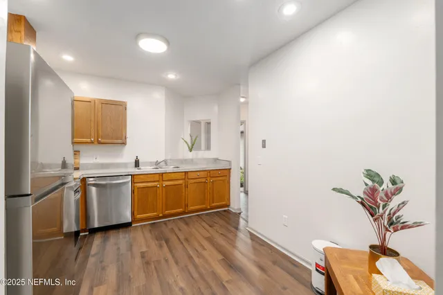 a kitchen with stainless steel appliances granite countertop a refrigerator a stove and a sink