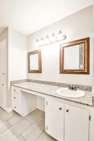 a bathroom with a granite countertop sink mirror and vanity