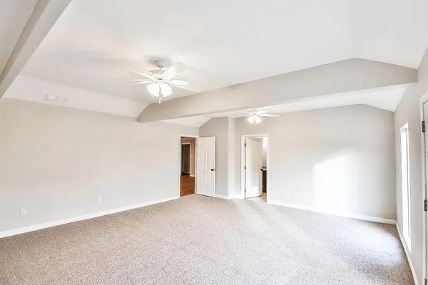 an empty room with a ceiling fan and a window