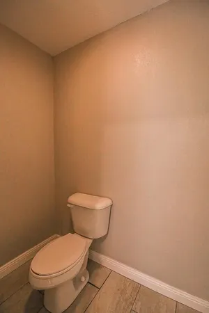 a white toilet sitting next to a white wall