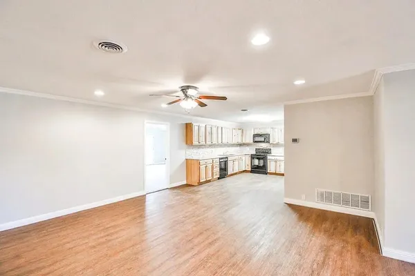 a view of a kitchen with cabinets and wooden floor