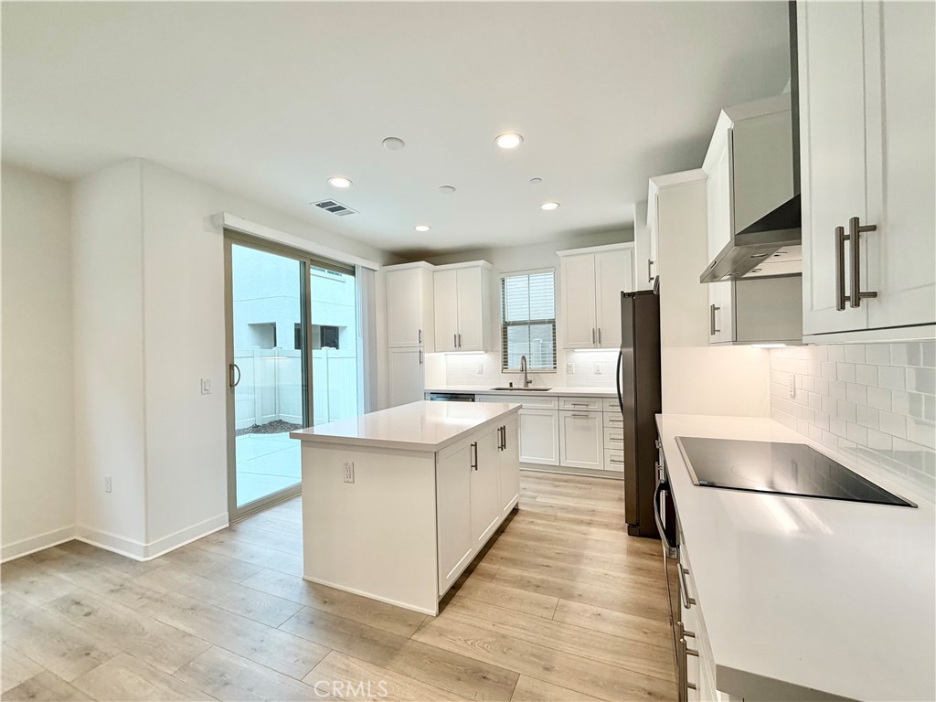 26893 Rubicon Road Menifee, CA 92586 - Photo 9 of 32 a large kitchen with a large counter top a sink stainless steel appliances and cabinets