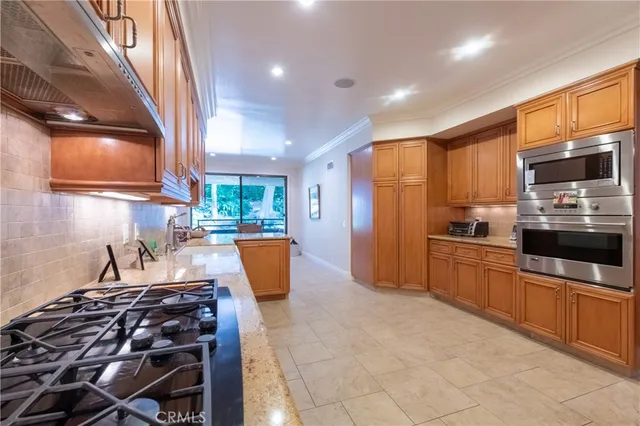 a kitchen with stainless steel appliances a stove a sink a microwave and a refrigerator