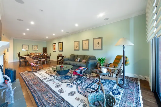 a living room with furniture a dining table and chairs with wooden floor