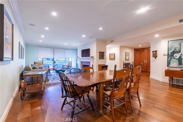 a view of a dining room and livingroom with furniture wooden floor a rug a painting and a chandelier