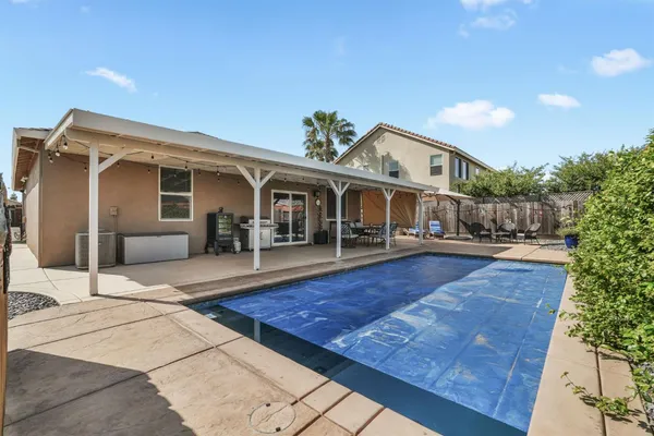 a view of a house with pool and sitting area