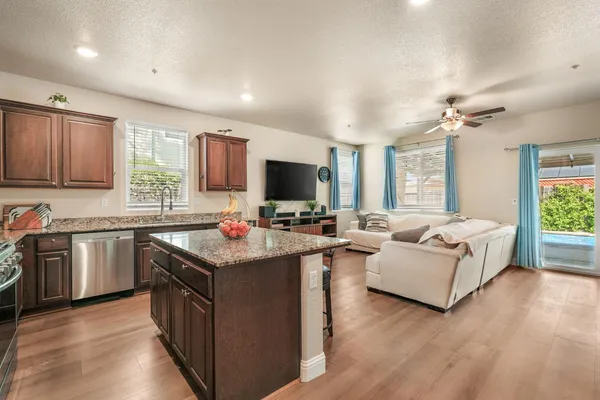 a kitchen with kitchen island granite countertop a sink counter top space appliances and a window