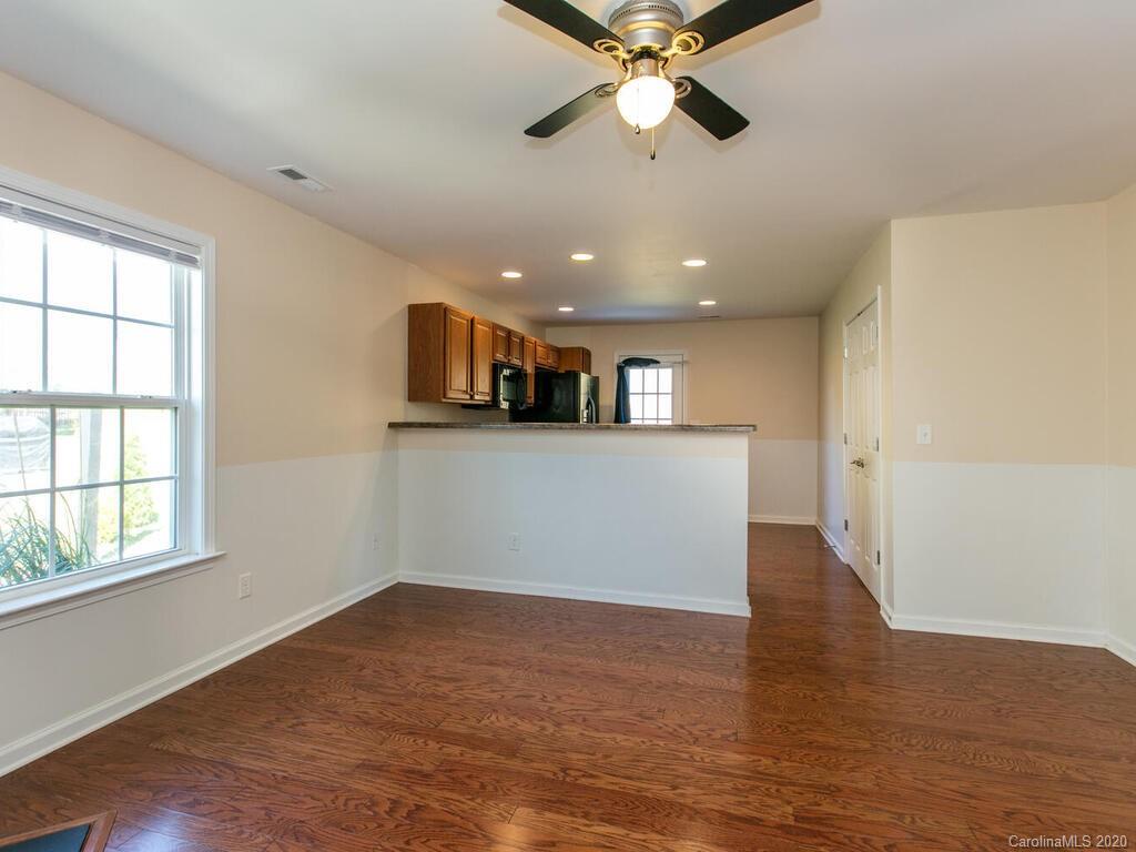 244 Lumber River Road Fletcher, NC 28732 - Photo 11 of 36 an empty room with wooden floor chandelier fan and windows