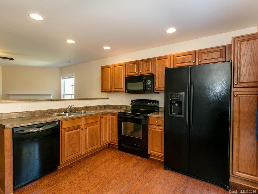 244 Lumber River Road Fletcher, NC 28732 - Photo 13 of 36 a kitchen with stainless steel appliances granite countertop a stove top oven a refrigerator and a sink
