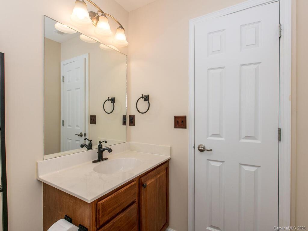 244 Lumber River Road Fletcher, NC 28732 - Photo 30 of 36 a bathroom with a sink vanity and a mirror