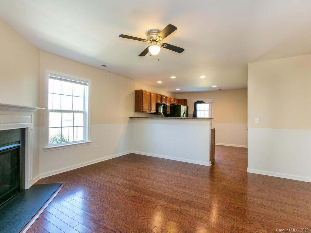 244 Lumber River Road Fletcher, NC 28732 - Photo 6 of 36 wooden floor in an empty room with a window and kitchen view