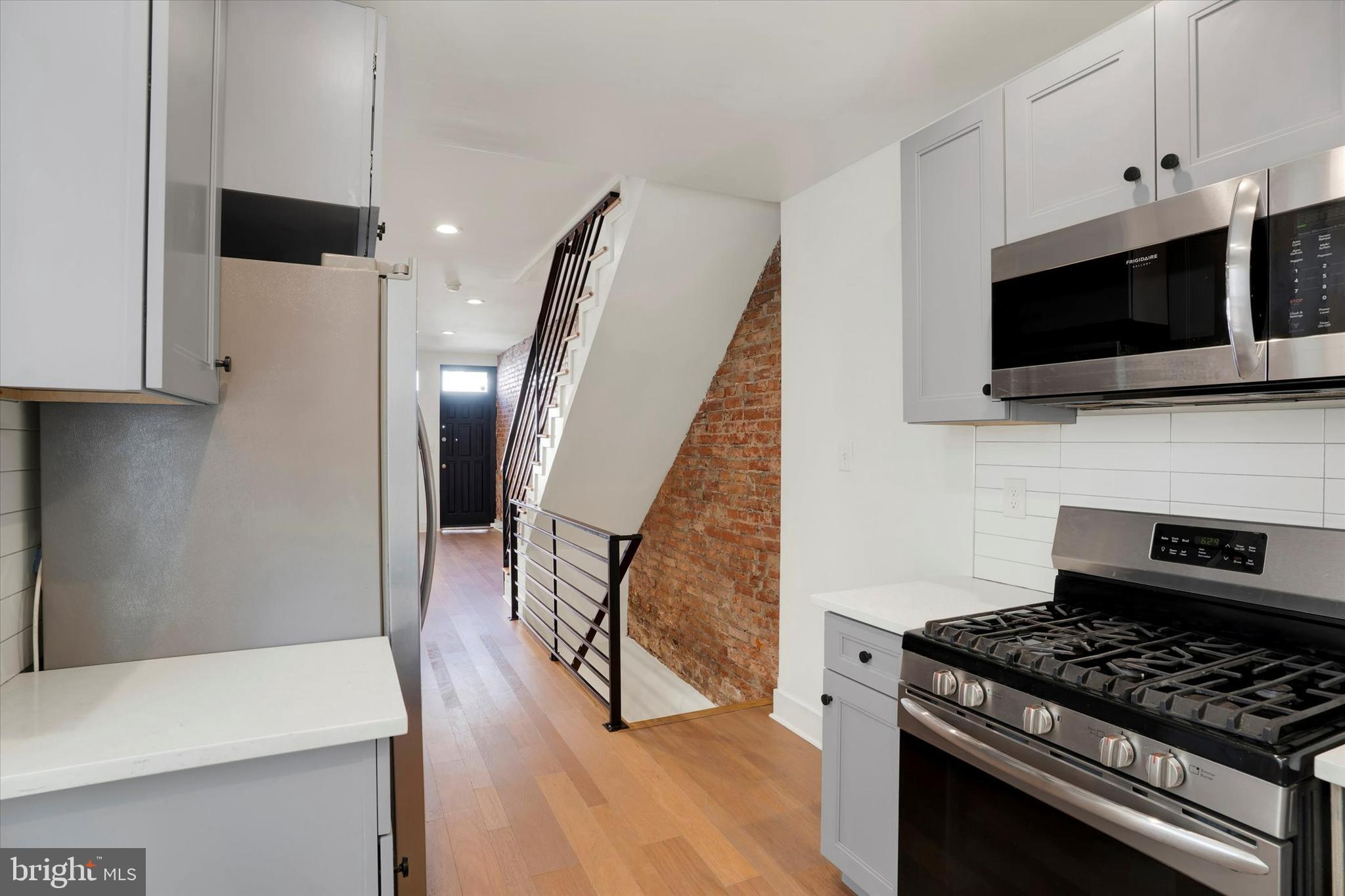 2636 Manton Street Philadelphia, PA 19146 - Photo 11 of 36 a kitchen with white cabinets and black appliances
