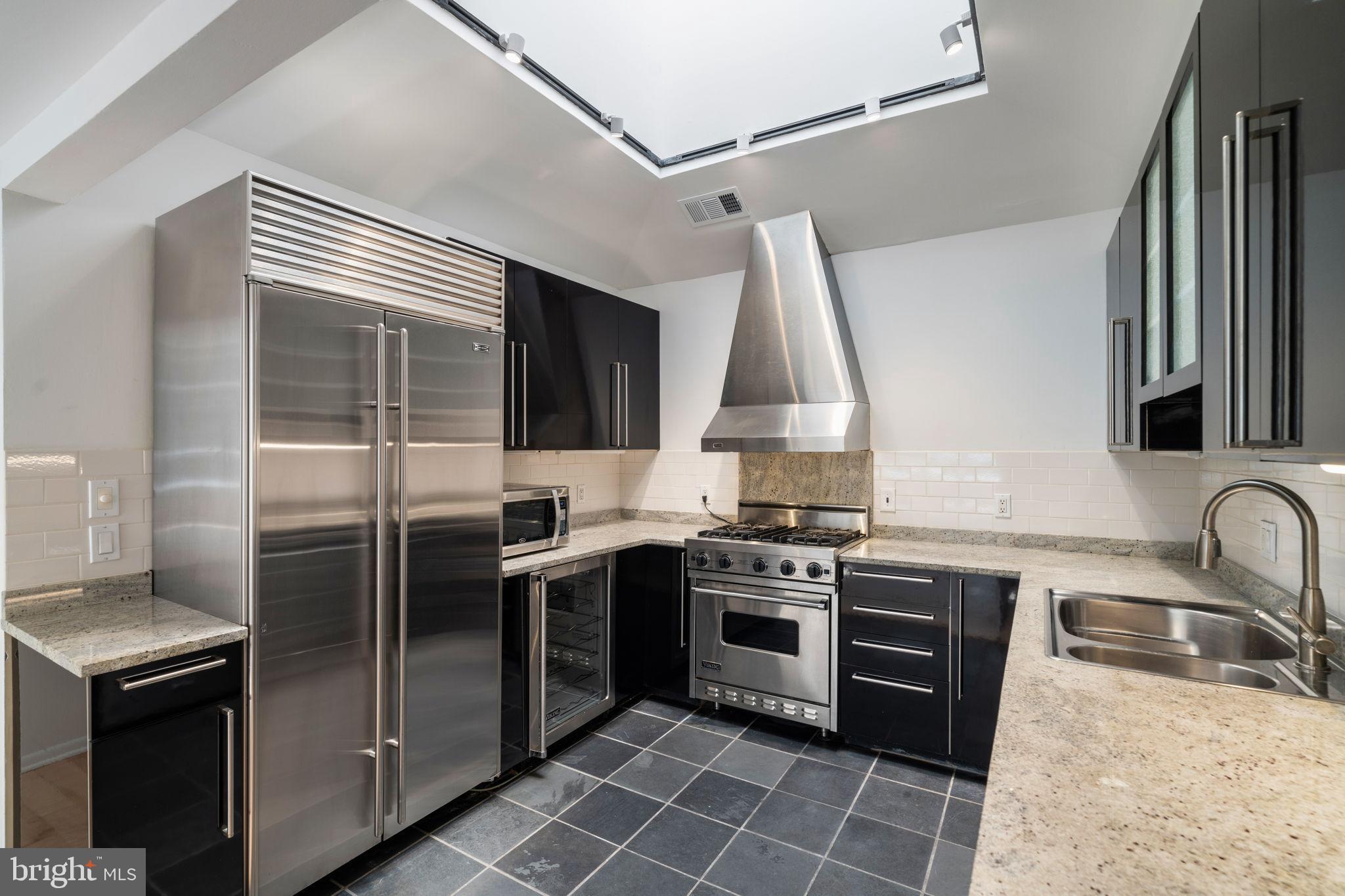 2036 Rittenhouse Square Philadelphia, PA 19103 - Photo 12 of 39 a kitchen with stainless steel appliances granite countertop a sink stove and refrigerator