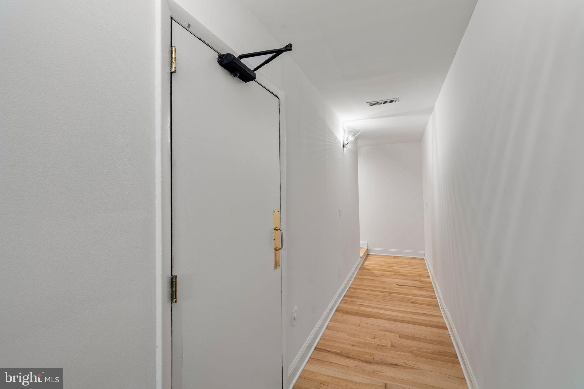 2036 Rittenhouse Square Philadelphia, PA 19103 - Photo 31 of 39 a view of a hallway with wooden floor and a bathroom