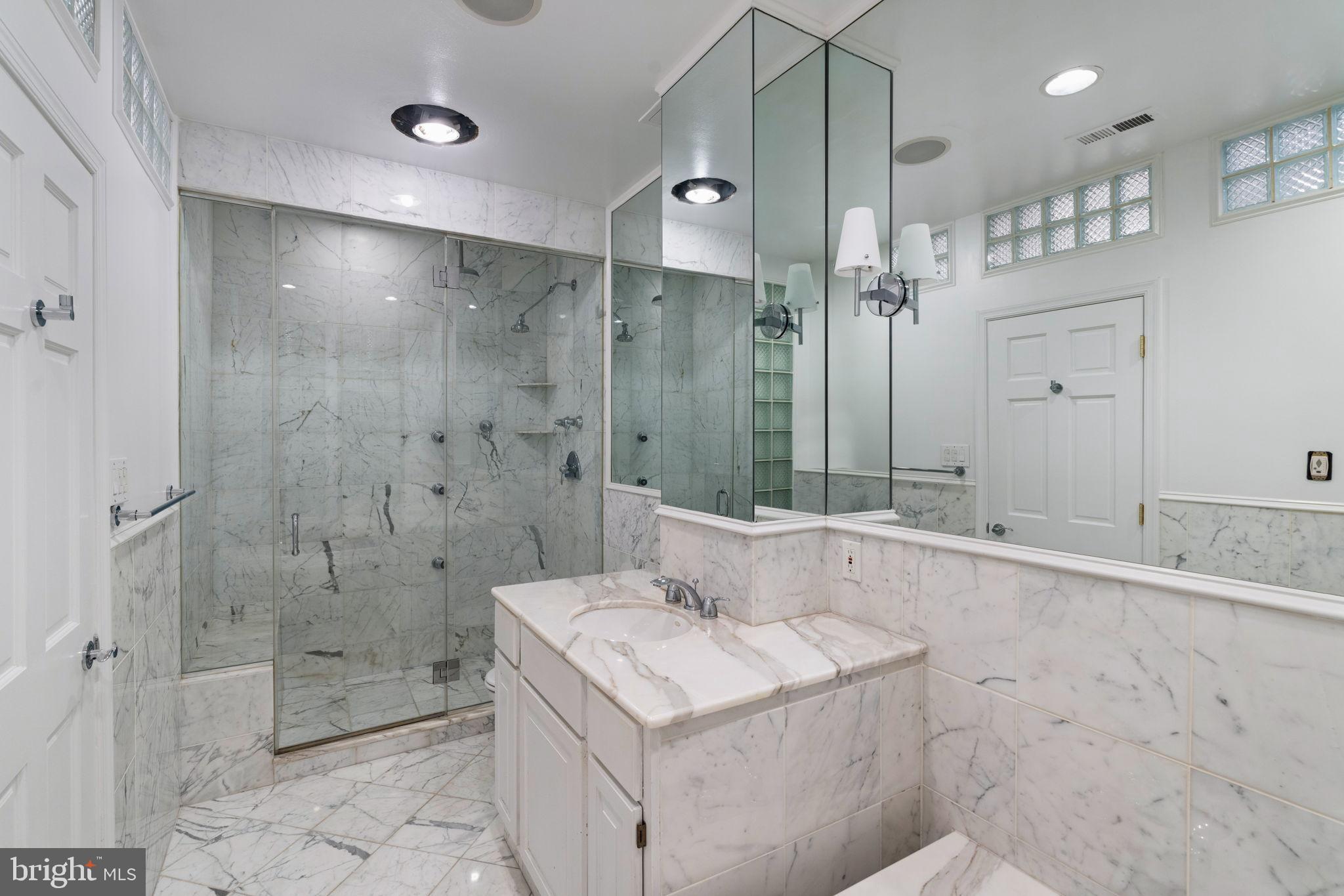 2036 Rittenhouse Square Philadelphia, PA 19103 - Photo 35 of 39 a bathroom with a granite countertop sink a shower and a mirror